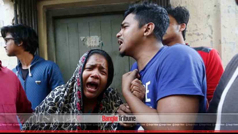 Idris (R) with his relatives mourn near the site of a burnt warehouse in Dhaka, Bangladesh, February 21, 2019. Bangla Tribune/Nashirul Islam.
