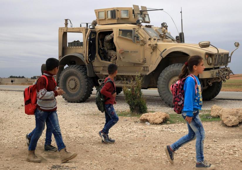 Syrian schoolchildren walk as US troops patrol near Turkish border in Hasakah, Syria Nov 4, 2018. REUTERS/File Photo