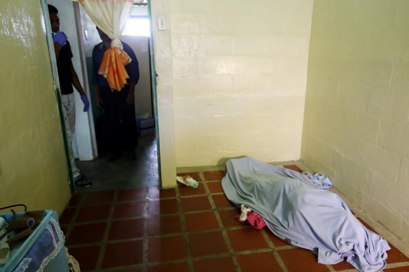 A body is seen covered inside a house after the Venezuelan soldiers opened fire on indigenous people near the border with Brazil on Friday, killing two, in Kumarakapay, Venezuela, Feb 22, 2019. REUTERS