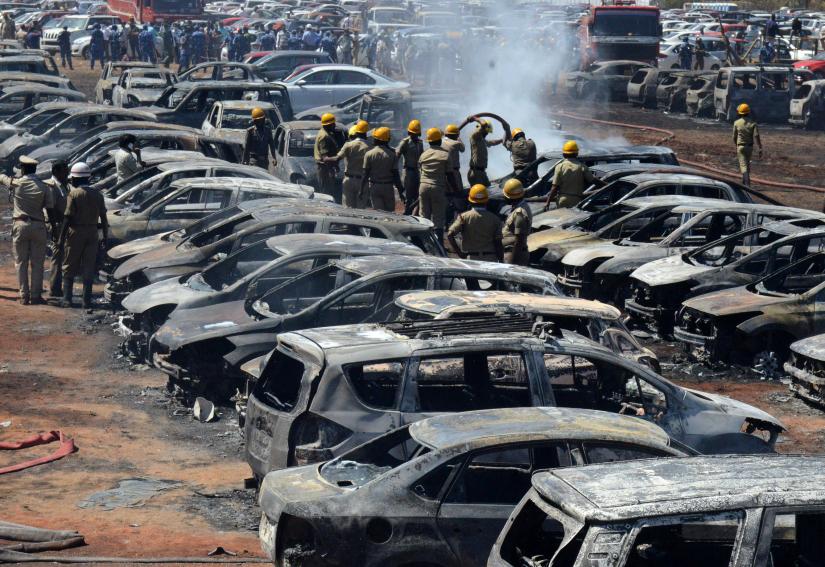 Firefighters extinguish smouldering cars after a fire broke out in a parking lot during the Aero India show at the Yelahanka Air Force Station in Bengaluru, India, February 23, 2019. REUTERS