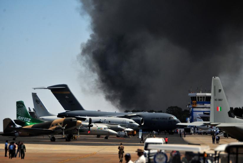 Smoke billows past a row of parked planes after a fire broke out in a parking lot during the Aero India show at the Yelahanka Air Force Station in Bengaluru, India, February 23, 2019. REUTERS