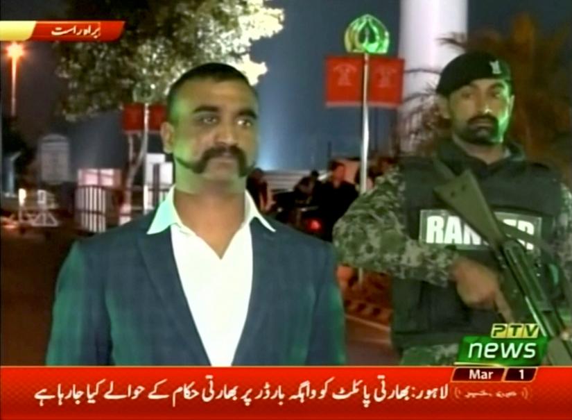 Indian pilot, Wing Commander Abhinandan, stands under armed escort near Pakistan-India border in Wagah, Pakistan in this March 1, 2019 image from a video footage. REUTERS/PTV via Reuters TV
