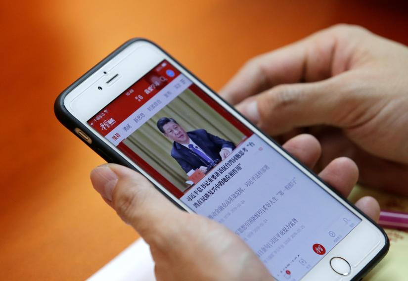 A party member, employee of Tidal Star Group, uses his mobile phone to attend a weekly group study in an app Xuexi Qiangguo, which literally translates as `Study to make China strong`, at a party activity room in Beijing, China, February 25, 2019. Picture taken February 25, 2019. REUTERS