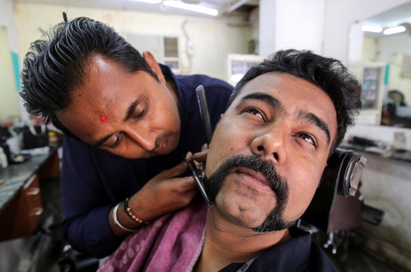 Dhiren Makvana gets his moustache trimmed similar to the one sported by Indian Air Force pilot Abhinandan Varthaman, who was captured and later released by Pakistan, inside a salon in Ahmedabad, India, March 4, 2019. REUTERS