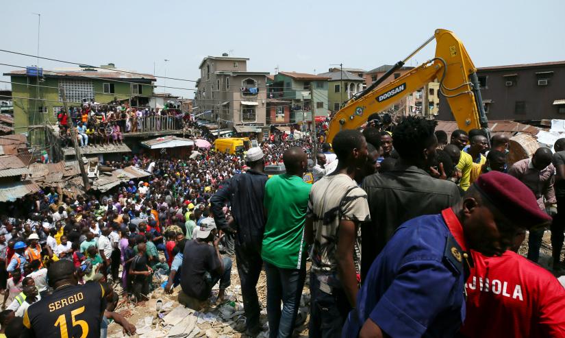 People watch rescue workers at the site of a collapsed building containing a school in Nigeria`s commercial capital of Lagos, Nigeria March 13, 2019. REUTERS