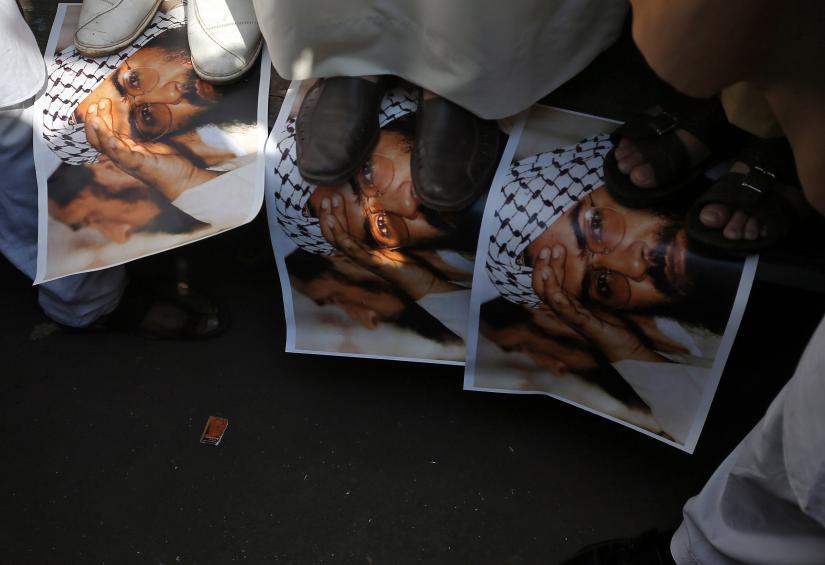 Demonstrators step on the posters of Maulana Masood Azhar, head of Pakistan-based militant group Jaish-e-Mohammad which claimed attack on a bus that killed 44 Central Reserve Police Force (CRPF) personnel in south Kashmir on Thursday, during a protest in Mumbai, India, February 15, 2019. REUTERS