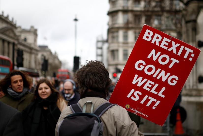 An anti-Brexit protester walks outside the Houses of Parliament in London, Britain March 14, 2019. REUTERS