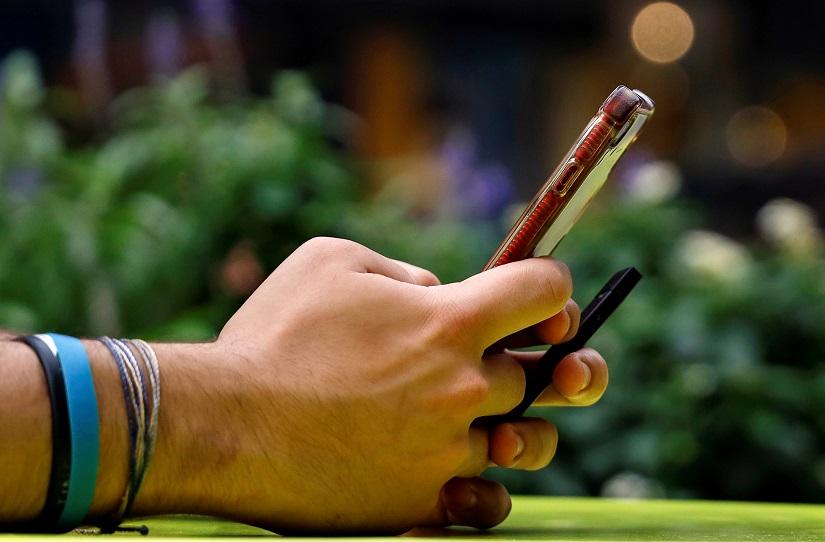 A man holds a Juul e-cigarette as he uses his phone in New York City, US, Sept 13, 2018. REUTERS/File Photo