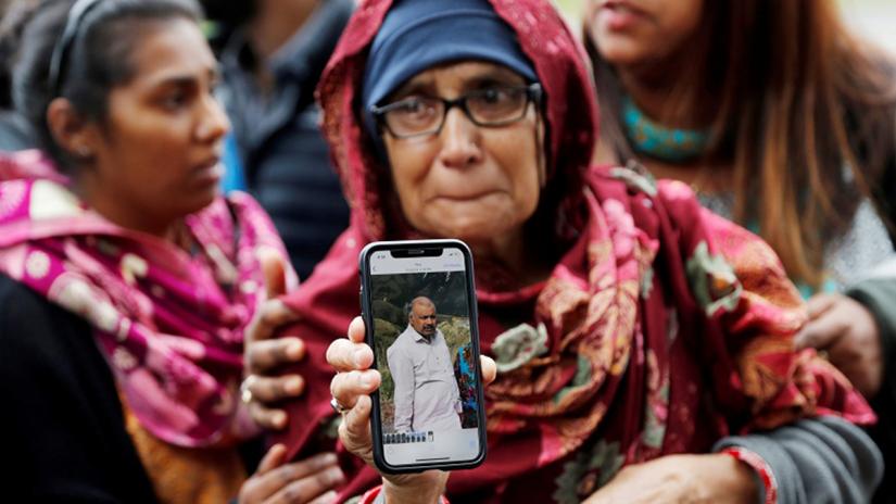 Aktar, holds up a photo of her husband who she says is missing after Friday`s mosque attacks, outside a community center near Masjid Al Noor in Christchurch, New Zealand, March 16, 2019. REUTERS