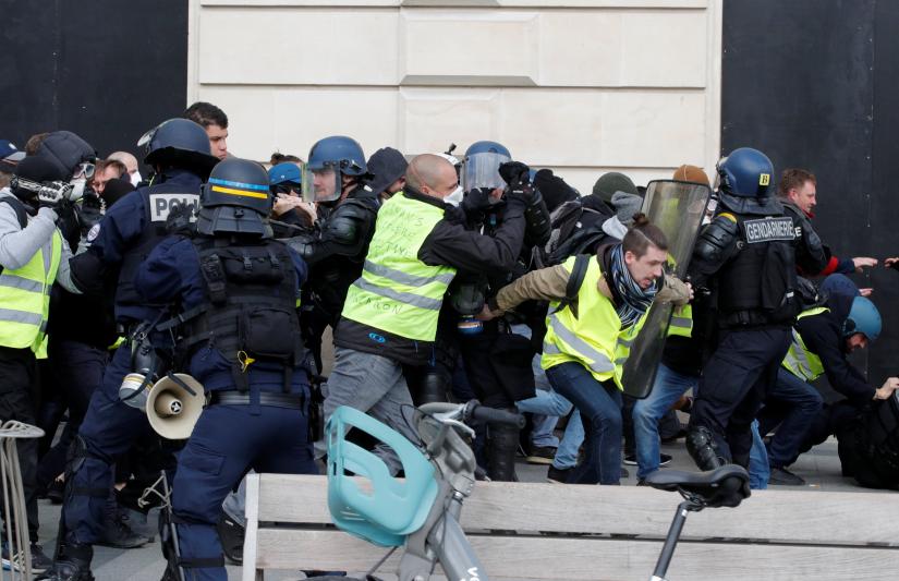 Protesters wearing yellow vests clash with French riot police during a demonstration by the `yellow vests` movement in Paris, France, March 16, 2019. REUTERS