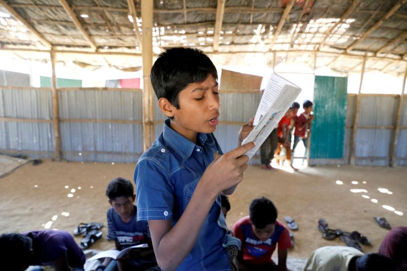 A child read a book in a make-shift school run by Rohingya teachers in Kutupalong refugee camp in Cox’s Bazar, Bangladesh, February 7, 2019. Picture taken February 7, 2019. REUTERS