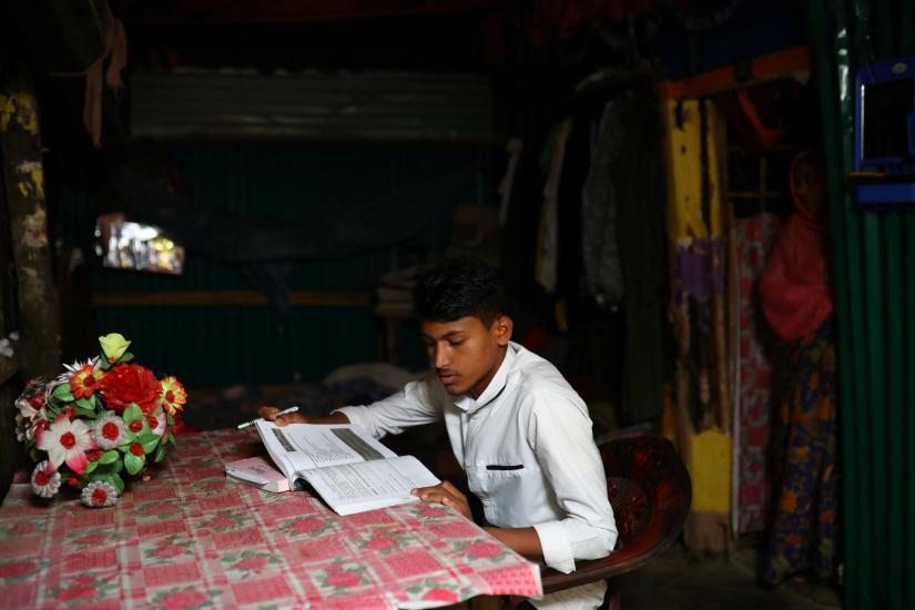Kefayat Ullah, a Rohingya boy who was expelled from Leda High School for being a Rohingya, studies in his shelter in Leda camp in Teknaf, Bangladesh, March 5, 2019. REUTERS