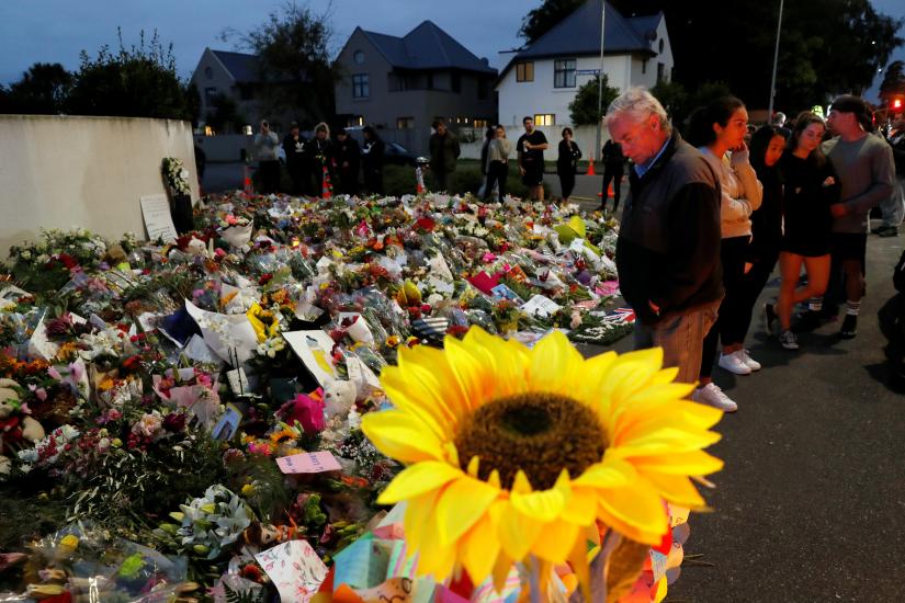 People visit a memorial site for victims of Friday`s shooting, in front of the Masjid Al Noor mosque in Christchurch, New Zealand March 18, 2019. REUTERS