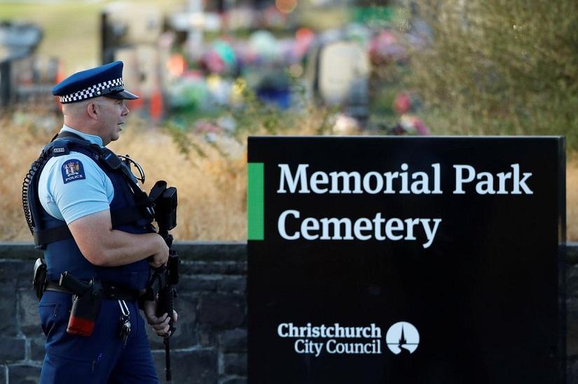 An armed policeman stands guard as the burial ceremony of the victims of the mosque attacks takes place at the Memorial Park Cemetery in Christchurch, New Zealand March 20, 2019. REUTERS