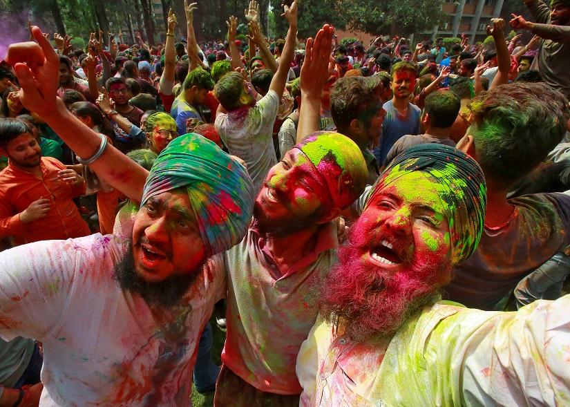 Students with their faces smeared in coloured powder dance as they celebrate Holi at a university campus in Chandigarh, India, March 20, 2019. REUTERS