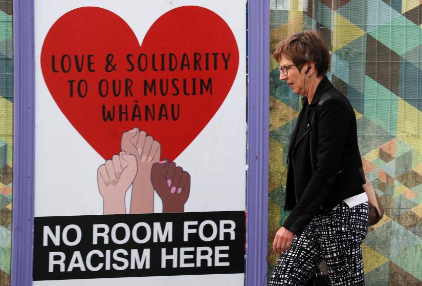 A woman walks past posters after last Friday`s mosque attacks in Christchurch, New Zealand March 21, 2019. REUTERS