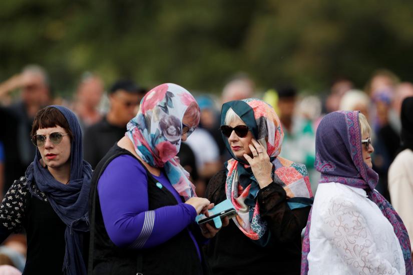 Women wearing headscarves as tribute to the victims of the mosque attacks are seen before Friday prayers at Hagley Park outside Al-Noor mosque in Christchurch, New Zealand March 22, 2019. REUTERS
