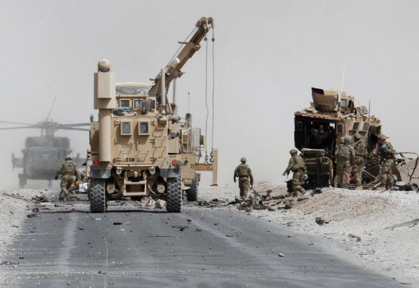 US troops assess the damage to an armoured vehicle of NATO-led military coalition after a suicide attack in Kandahar province. REUTERS/File Photo