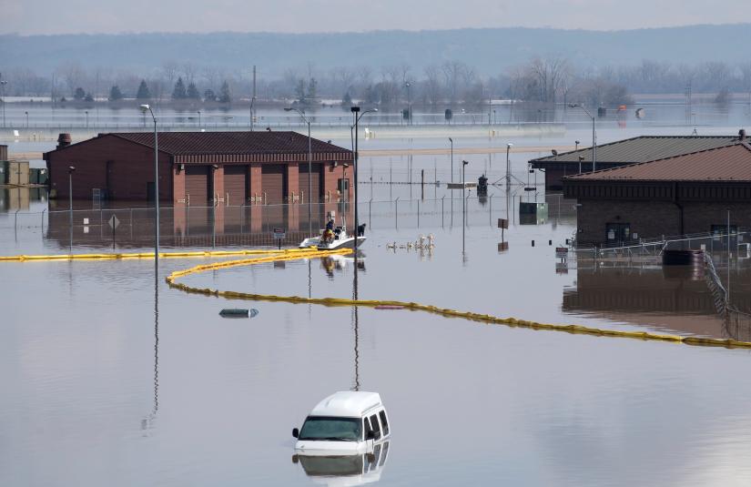 Contracted employees of the Environmental Restoration, LLC company deploy a spill containment boom around the fuel storage area, following flooding of the southeast portion of the Offutt Air Force Base, Nebraska, U.S., March 18, 2019. Picture taken on March 18, 2019. Courtesy Delanie Stafford/U.S. Air Force/Handout via REUTERS