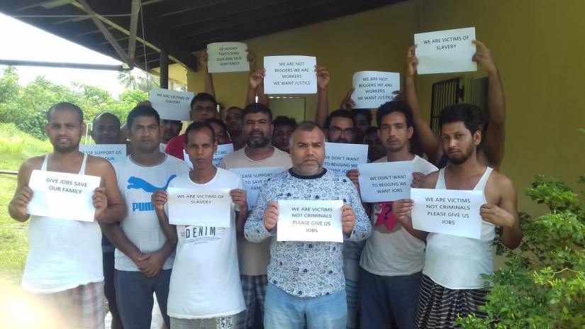 Bangladeshi migrant workers hold signs requesting help and support after they are stranded in Vanuatu. PHOTO/Vanuatu Daily Post