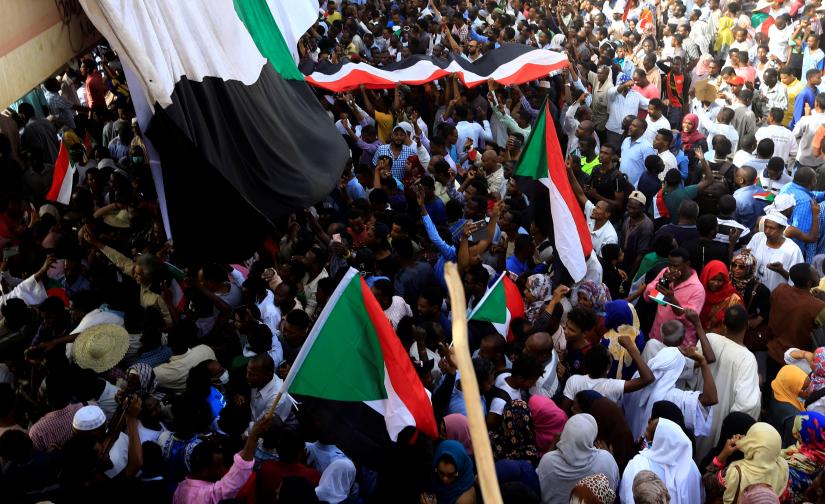 Sudanese demonstrators wave their national flag as they attend a protest rally demanding Sudanese President Omar Al-Bashir to step down outside the Defence Ministry in Khartoum, Sudan April 11, 2019. REUTERS