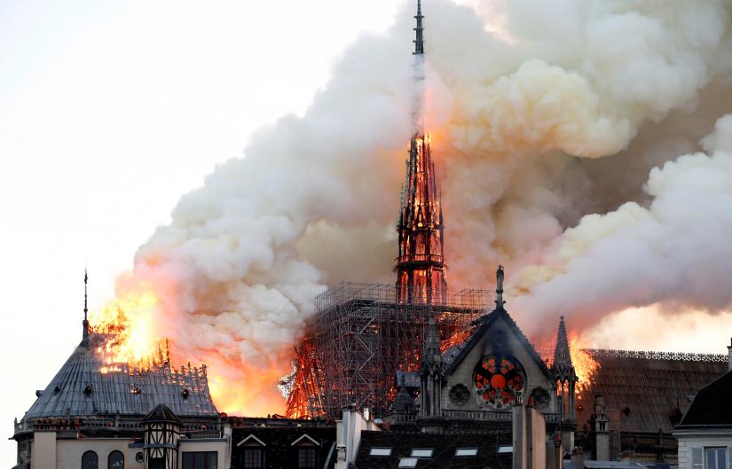 Smoke billows as fire engulfs the spire of Notre Dame Cathedral in Paris, France April 15, 2019. REUTERS