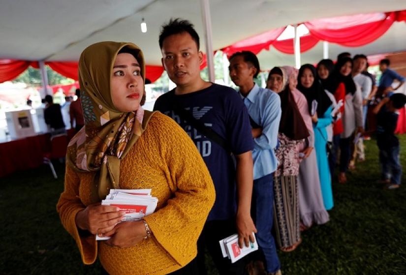 Voters queue up to vote at a polling booth during elections in Bogor, West Java, Indonesia April 17, 2019. REUTERS