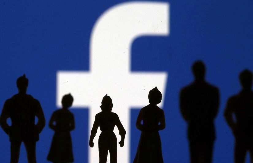Small toy figures are seen in front of Facebook logo in this illustration picture, Apr 8, 2019. REUTERS/File Photo