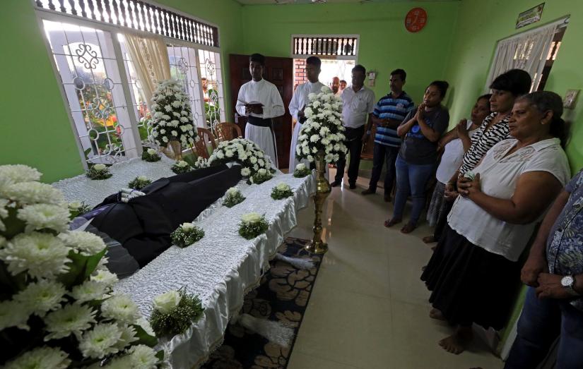 Friends and relatives pray near the body of Muthuwadige George Dencil Fernando, who died in blast.
