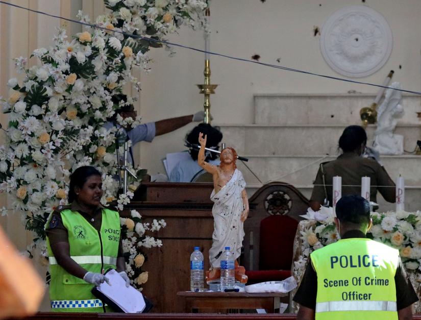 Police officers work at the scene at St. Sebastian Catholic Church in Negombo