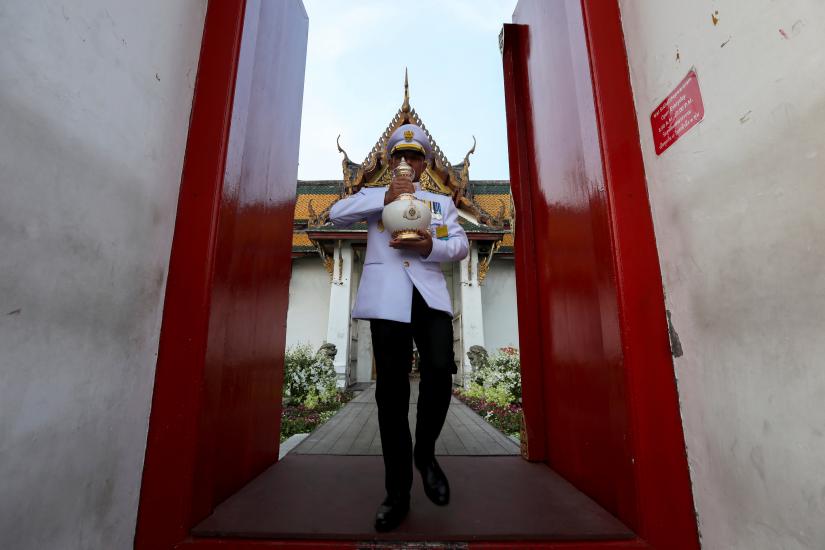 A royal official holds an ewer containing sacred water to be consecrated for the coronation for Thailand`s New King