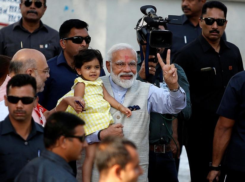 India`s Prime Minister Narendra Modi gestures as he holds the granddaughter of India`s ruling Bharatiya Janata Party (BJP) president Amit Shah after he arrives to cast his vote at a polling station during the third phase of general election in Ahmedabad, India, April 23, 2019. REUTERS