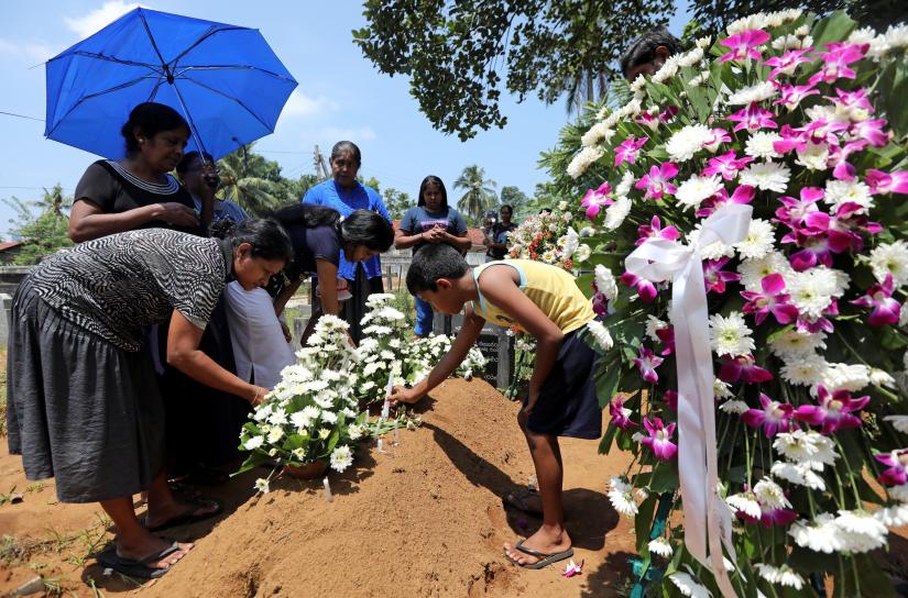 Family put flowers on the grave of Rexy Duglas, 67, three days after a string of suicide bomb attacks on churches and luxury hotels across the island on Easter Sunday, at a cemetery near St Sebastian`s Church in Negombo, Sri Lanka April 24, 2019. REUTERS