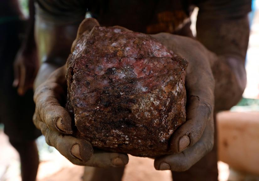 An artisanal miner holds up a rock containing gold that was removed from inside a mining pit at the unlicensed mining site of Nsuaem Top in Ghana, November 24, 2018. Picture taken November 24, 2018. REUTERS