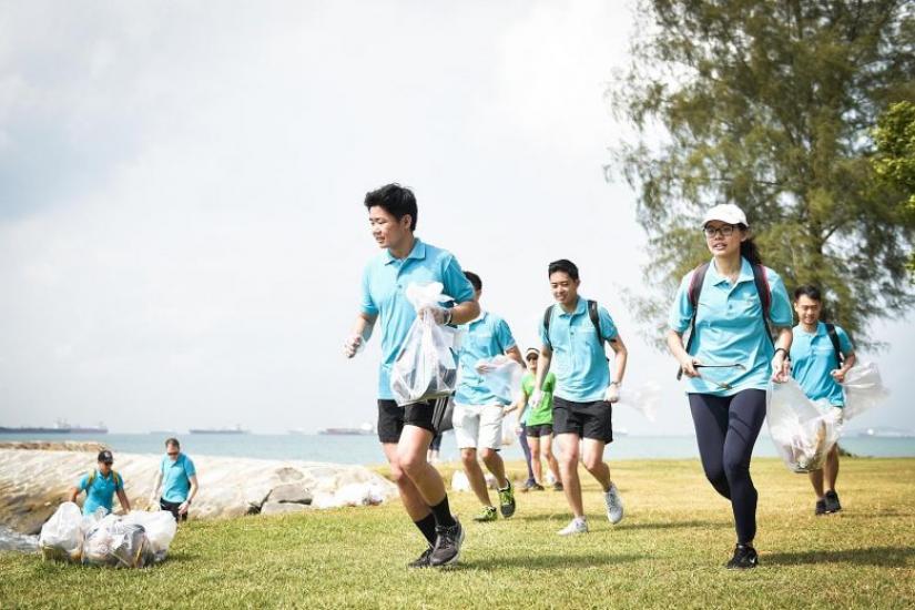 Mr Lee Leong Hui (in front) plogging at the East Coast beach with his colleagues from property firm Lendlease, as part of the company`s annual community day.