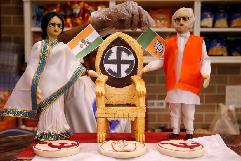 A confectioner decorates a chair beside the models, made out of sweets, depicting Chief Minister of West Bengal state Mamata Banerjee and Prime Minister Narendra Modi at a sweets shop ahead of the second phase of general election, in Kolkata, India, April 13, 2019. REUTERS