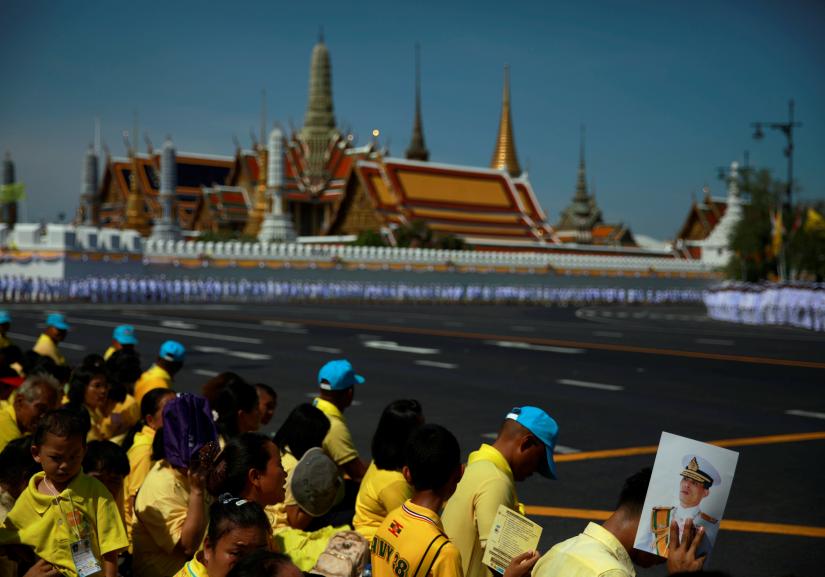 A member of the public holds an image of King Maha Vajiralongkorn during his coronation outside the Grand Palace in Bangkok, Thailand, May 4, 2019. REUTERS