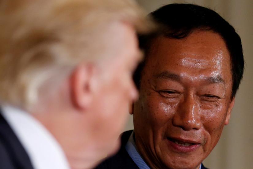 FILE PHOTO: Foxconn Chairman Terry Gou (R) smiles as U.S. President Donald Trump (L) delivers remarks during a White House event where the Taiwanese electronics manufacturer announced plans to build a $10 billion dollar LCD display panel screen plant in Wisconsin, in Washington, U.S. July 26, 2017. REUTERS