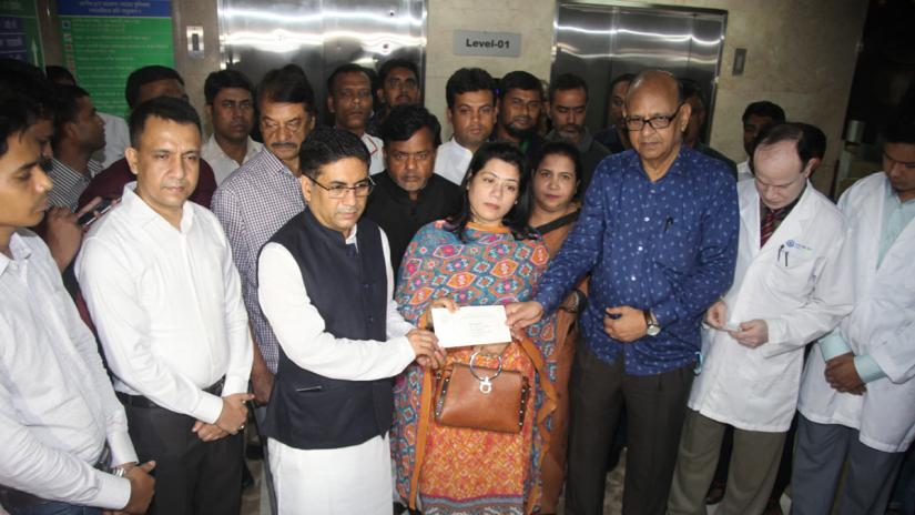 Prime Minister Sheikh Hasina`s special assistant Barrister Biplob Barua handed over the cheque to Shamsuzzaman`s daughter Koyel at Asgar Ali Hospital in Old Dhaka on Monday (May 13).