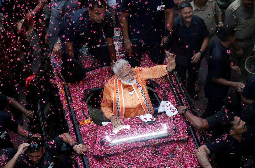 India`s Prime Minister Narendra Modi waves towards his supporters during a roadshow in Varanasi, India, April 25, 2019. REUTERS