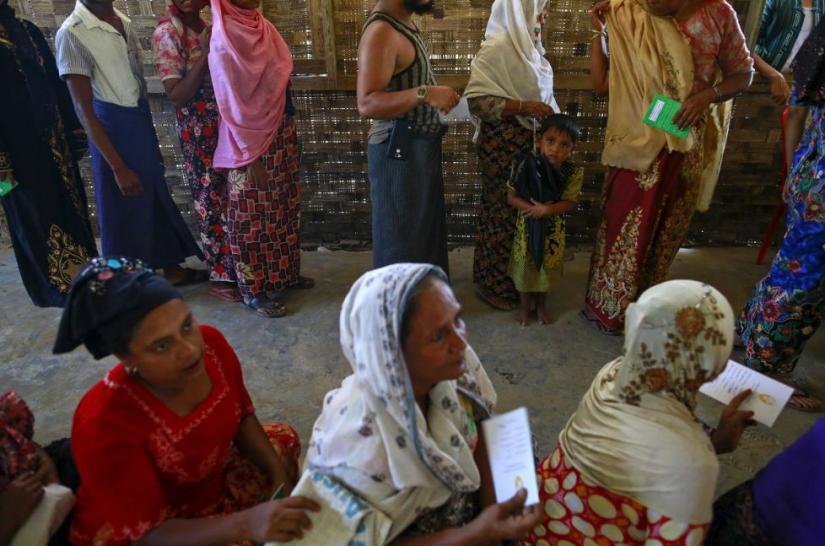 FILE PHOTO: Rohingya Muslims line up to receive aid at a refugee camp outside Sittwe, Myanmar May 20, 2015. REUTERS