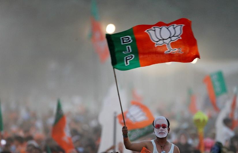 A supporter of India`s ruling Bharatiya Janata Party (BJP) waves the party flag during an election campaign rally being addressed by India`s Prime Minister Narendra Modi in New Delhi, India, May 8, 2019. REUTERS/File Photo