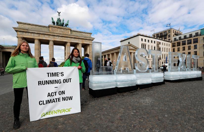 Greenpeace environmental group stage a protest with words made of ice at the Brandenburg Gate near the venue of a session of the Petersberg Climate Dialogue, an informal meeting of ministers and representatives from 35 countries focused on the implementation of the Paris Climate Agreement in Berlin, Germany, May 14, 2019. REUTERS