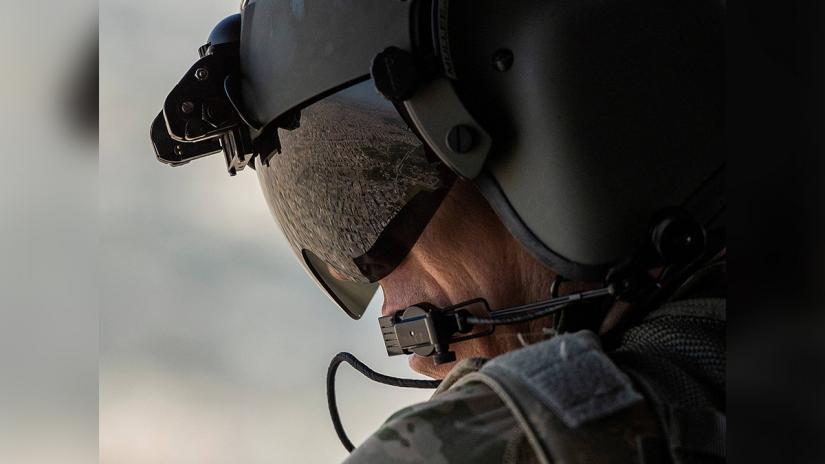A partial view of the Iraqi capital Baghdad is reflected in the visor of a US Army helicopter crew member as he looks out of a Chinook helicopter flying from the US Embassy to Baghdad International airport on Jan 9, 2019. Reuters/File Photo