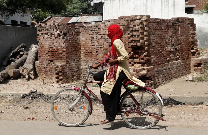 A girl cycles past the ruins of an incomplete mosque, a dispute over which led to communal riots in which two died in 1977, in village Nayabans in the northern state of Uttar Pradesh, India May 15, 2019. Picture taken on May 15, 2019. REUTERS