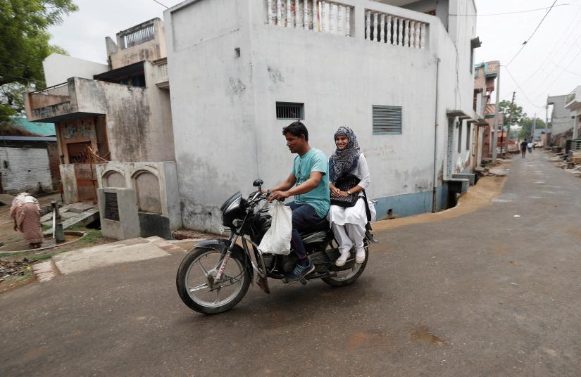 Sharfuddin, a cloth shop owner and his niece Aisha, a law student, ride a motorbike in village Nayabans in the northern state of Uttar Pradesh, India May 15, 2019. Picture taken May 15, 2019. REUTERS