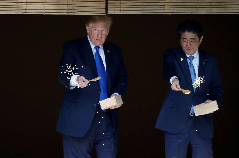 FILE PHOTO: US President Donald Trump and Japan`s Prime Minister Shinzo Abe feed carp before their working lunch at Akasaka Palace in Tokyo, Japan November 6, 2017. REUTERS
