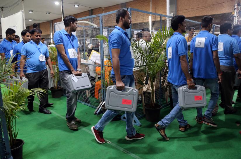 Election staff members carry electronic voting machines (EVM) at a vote counting centre in Mumbai, India, May 23, 2019. REUTERS