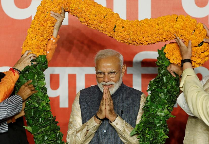 Indian Prime Minister Narendra Modi gestures as he is presented with a garland by Bharatiya Janata Party (BJP) leaders after the election results in New Delhi, India, May 23, 2019. REUTERS