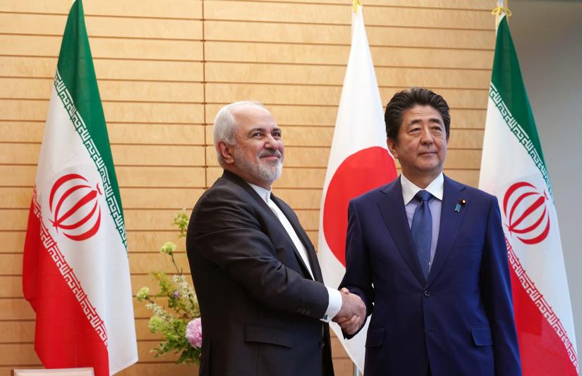Iranian Foreign Minister Mohammad Javad Zarif, left, and Japanese Prime Minister Shinzo Abe, right, shake hands at Abe`s official residence in Tokyo Thursday, May 16, 2019. Eugene Hoshiko/Pool via REUTERS